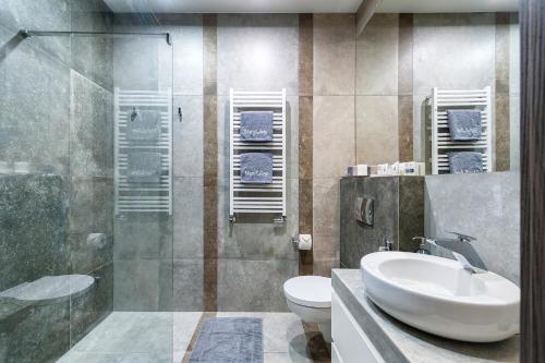 a bathroom with a sink and a toilet and a shower at Mary&Arte Apartments Browar Lubicz in Kraków
