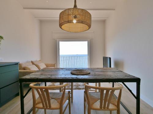 a dining room with a table with chairs and a couch at Casa Concha Apartamentos in Calella de Palafrugell