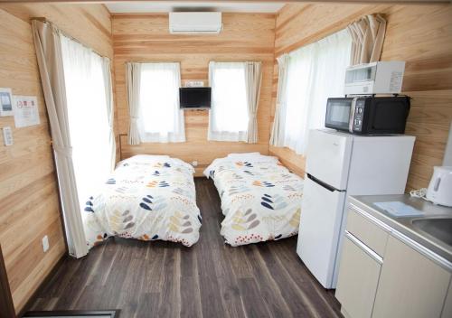 a small kitchen with two beds in a tiny house at Station Villa Plaisir Mt. Fuji in Fujikawaguchiko