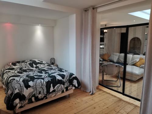 une chambre avec un lit avec une couverture noire et blanche dans l'établissement Shamshouse/Garage, à Dol-de-Bretagne