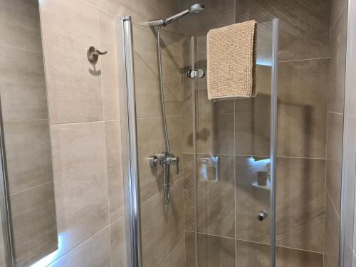 La salle de bains est pourvue d'une douche avec une porte en verre. dans l'établissement Calella Playa Vistas Mar, à Calella