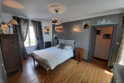 une chambre avec un lit blanc et une fenêtre dans l'établissement Maison Jeanne (proche Bécherel pour 14 personnes), à Saint-Pern