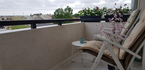 a balcony with a chair and a table and a window at Musura Bay Apartments in Sulina