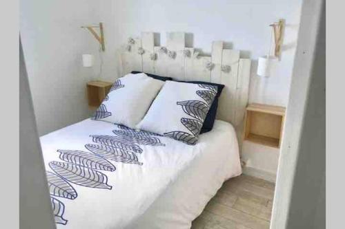 une chambre avec un lit avec des draps blancs et des oreillers dans l'établissement Cabourg-la mer à perte de vue, à Cabourg