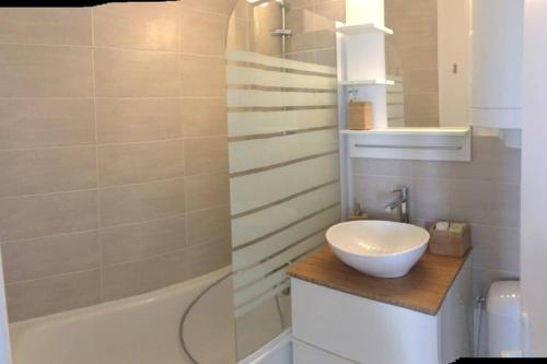 une salle de bain avec un lavabo et une baignoire et un lavabo dans l'établissement Cabourg-la mer à perte de vue, à Cabourg