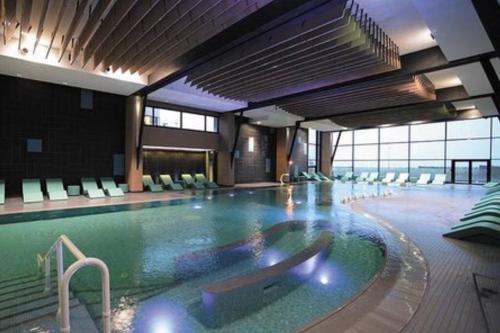 une grande piscine dans un grand bâtiment dans l'établissement Cabourg-la mer à perte de vue, à Cabourg