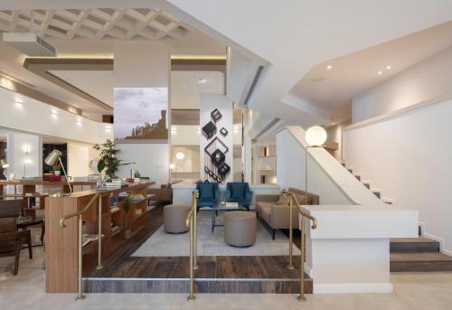 a lobby with tables and chairs and a staircase at Cassia Hotel Jerusalem in Jerusalem