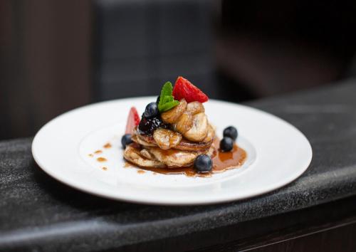 een bord met eten en fruit op tafel bij Rezydencja Sowa in Bydgoszcz