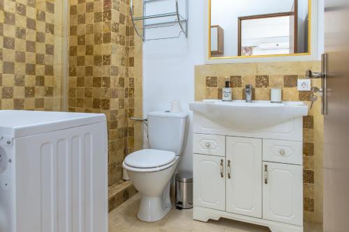 ein Badezimmer mit weißer Toilette und Waschbecken in der Unterkunft Morsky in Năvodari