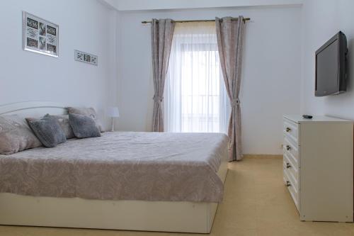 ein Schlafzimmer mit einem Bett, einem TV und einer Kommode in der Unterkunft Morsky in Năvodari
