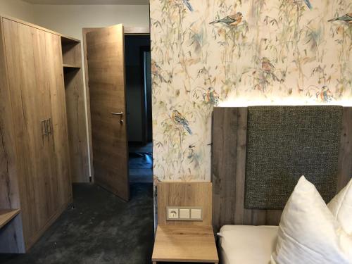 a bedroom with a bed and a wall with a wallpaper at Gasthof Wiesenhof in Strobl