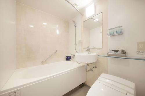 uma casa de banho com uma banheira, um lavatório e um WC. em Keisei Richmond Hotel Tokyo Monzennakacho em Tóquio