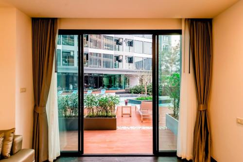 a room with a sliding glass door to a courtyard at The Proud Hotel Pattaya - SHA Certified in Pattaya North