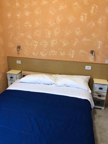 a bedroom with a blue bed with two night stands at La veranda in Ardea