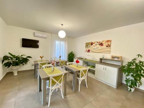 uma cozinha e sala de jantar com mesas e cadeiras em B&B MiMì em Porto Cesareo