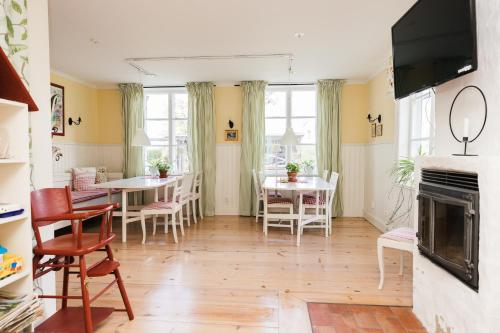 uma sala de estar com mesas e cadeiras e uma lareira em Bäcks Bed & Breakfast em Vintrosa