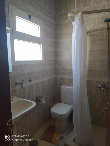 a bathroom with a toilet and a sink and a window at Studio 2 in Sharm El Sheikh