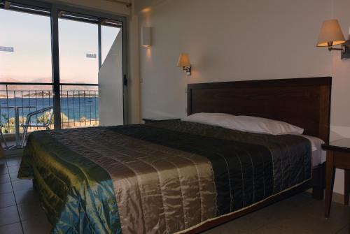 a bedroom with a bed and a view of the ocean at Mirabella Apartments in Agios Nikolaos