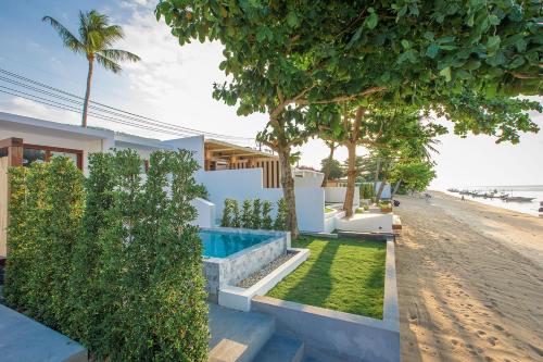 a villa with a swimming pool next to the beach at White Whale Beachfront Pool Villa in Ban Bang Po