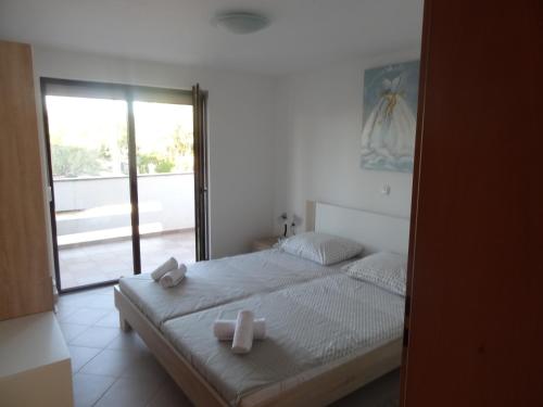 a bedroom with a bed with two crosses on it at Ilsad apartments, Apartment with pool 80 meters from se, Sea view from balcony in Ždrelac