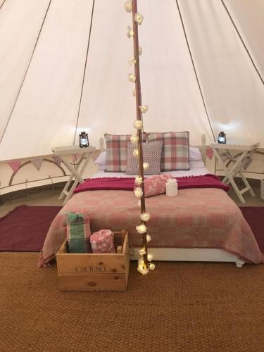 - une chambre avec un lit dans une tente dans l'établissement Cefn Crib Glamping, à Machynlleth