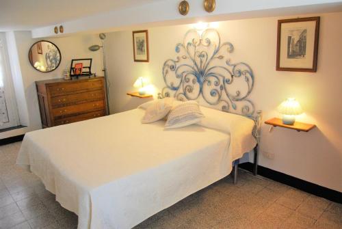 a bedroom with a large white bed with two lamps at A cà du Grillu - Casa Vacanze in Albisola Superiore