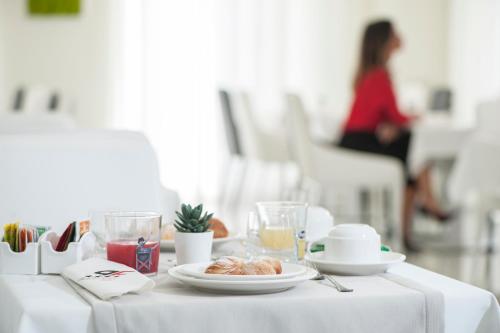 a white table with a plate of food on it at Palazzo Firenze in Naples