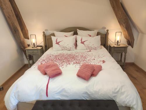 a bedroom with a white bed with two pillows at L'Amalgam' in Ainay-le-Vieil