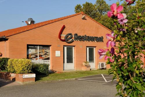 an orange building with a sign on the side of it at Campanile Toulouse Sud-Labège innopole in Labège