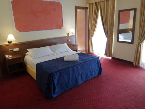 a hotel room with a bed with a laptop on it at Hotel Antiche Terme Benevento in Benevento