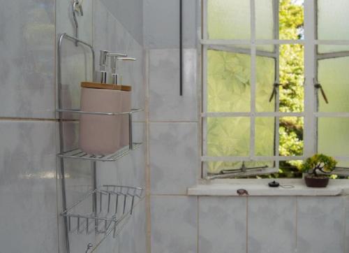 baño con ducha con lavabo y ventana en Kinghurst, City Apartment, en Lusaka