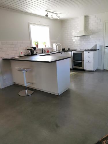 a white kitchen with a counter and a sink at Idyllisk nybyggd stuga på Sollerön. in Sollerön