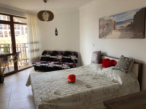 a bedroom with a bed with a red hat on it at Fregata Complex Marina in Sveti Vlas