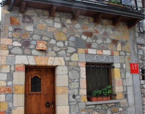 a stone building with a door and two windows at Caseta Sorripas in Bielsa