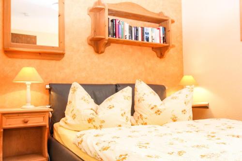- une chambre avec un lit doté d'oreillers et d'une étagère à livres dans l'établissement Likedeeler 5, à Zingst