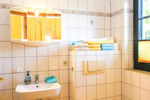 ein Badezimmer mit einem Waschbecken, einem Spiegel und Handtüchern in der Unterkunft Oliver-Grolik in Born