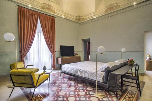 a bedroom with a bed and a desk and a chair at Regina Bianca - Camere, Suite & Spa - Sciacca in Sciacca