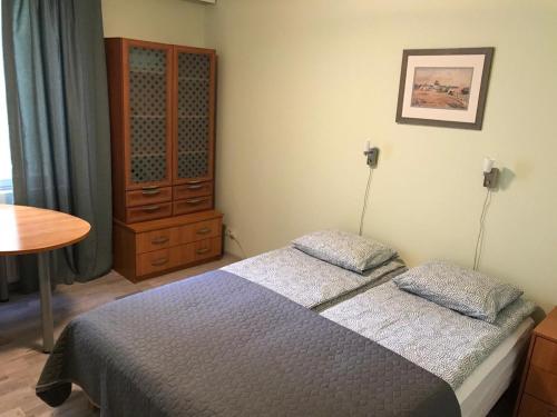 Un dormitorio con una cama, una cómoda y una mesa. en Spacious 1bdrm apartment near metro. Free parking, en Vantaa