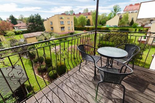 a patio with chairs and a table on a balcony at Astra Apartments in Oświęcim