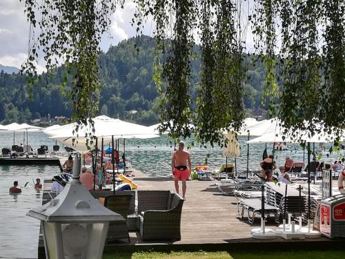 a woman walking on a dock next to a body of water at Pension Horvath in Sankt Kanzian