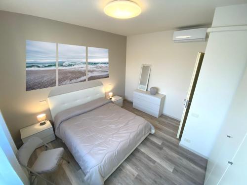 una camera da letto con un letto e un dipinto sul muro di CLARE HOUSE per una vacanza "CHIC" a Porto Recanati