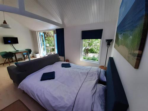 a bedroom with a bed and a couch at Boshuisje Petten aan Zee in Petten