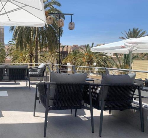 a group of chairs and tables with umbrellas on a patio at Catedral Almería in Almería