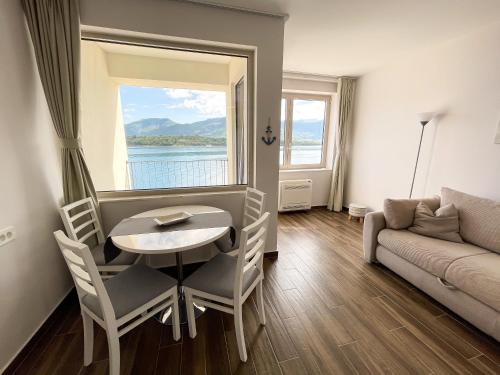 a living room with a table and chairs and a couch at Apartments Maestral in Tivat