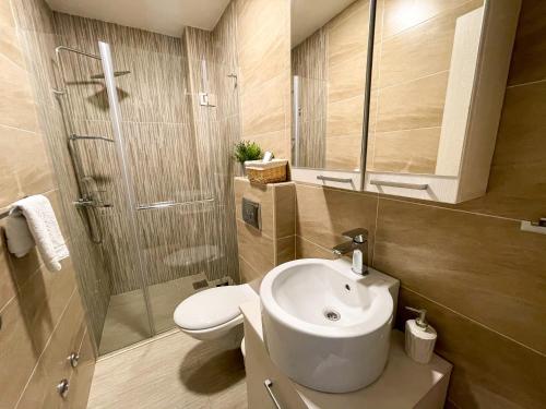 a bathroom with a toilet and a sink and a shower at Apartments Maestral in Tivat