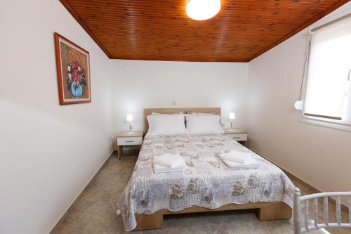 1 dormitorio con 1 cama con techo de madera en (Apt.4) Lofos Apartments in Vergia Halkidiki, en Sozopoli