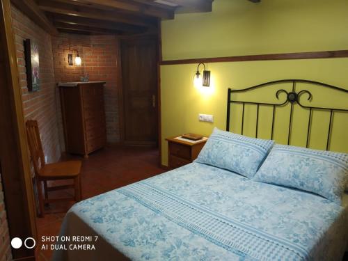 Un dormitorio con una cama con un edredón azul. en Apartamentos La Huerta de la Torre, en Cangas de Onís