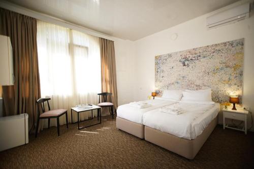 Una habitación de hotel con una cama y un cuadro en la pared. en Pawlonia Villa Kvareli, en Kvareli