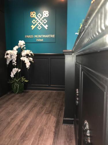 a room with flowers and a sign on the wall at Hotel de Paris Montmartre in Paris