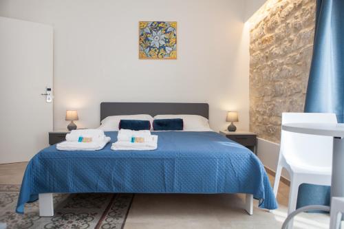 Un dormitorio con una cama azul con toallas. en Candelieri19, en Módica
